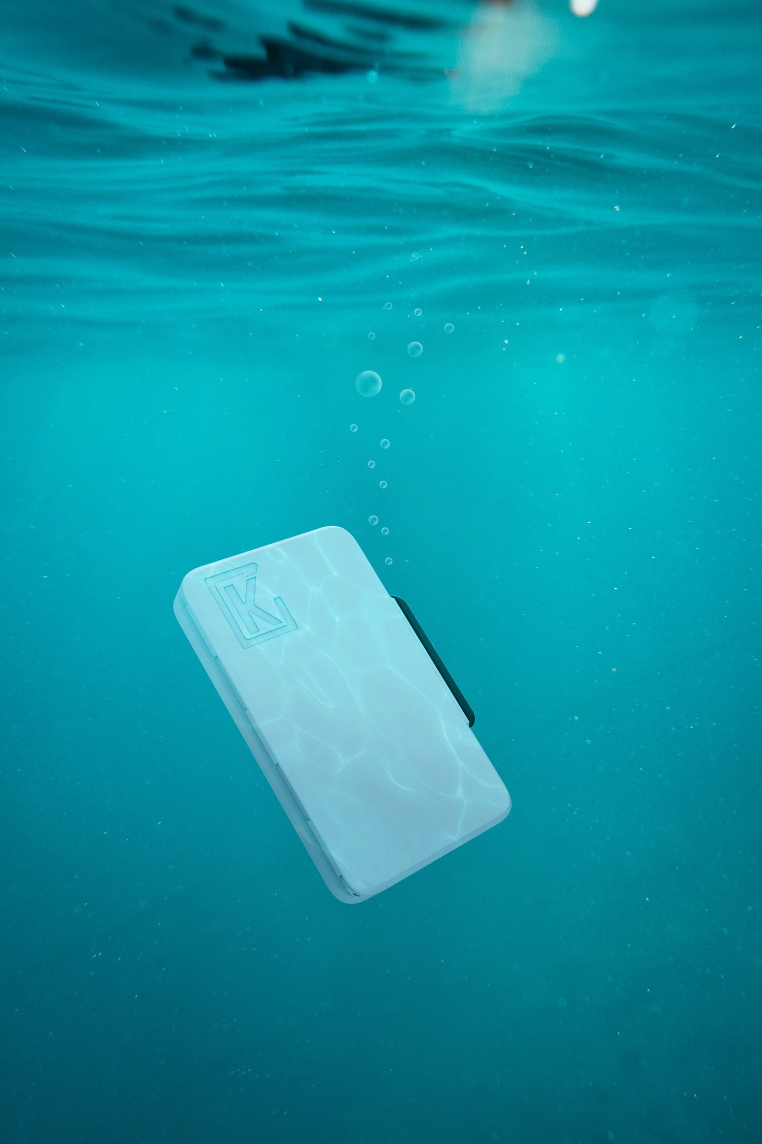 Photo of the white Kelo case fully submerged in water. The gasket seal makes this a water resistant joint case